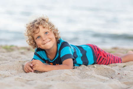 Portrait of a boy at sunset by the seaの写真素材