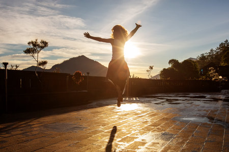 Woman doing yoga at dawn near a volcano on the island of Baliの写真素材