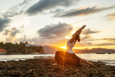 Woman doing yoga by the seaの写真素材