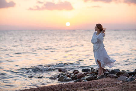 Beautiful woman relaxes by the seaの写真素材
