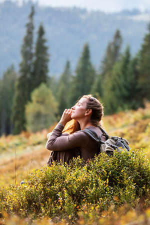 Woman hiker resting after climbing at sunsetの写真素材