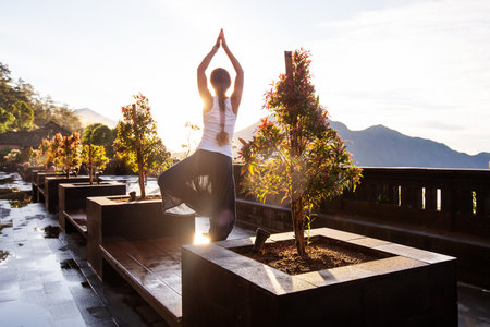 Woman doing yoga at dawn near a volcano on the island of Baliの写真素材