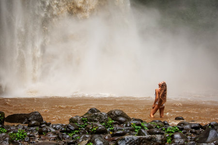 Beautiful woman near a waterfall in Baliの写真素材