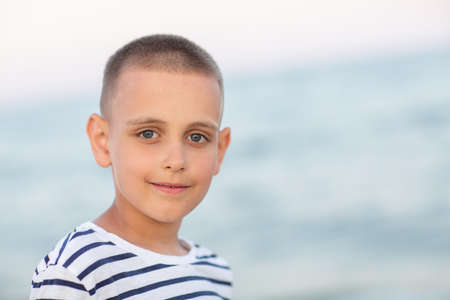 Portrait of a boy at sunset by the seaの写真素材
