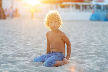 Portrait of a boy at sunset by the seaの写真素材