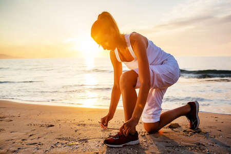 Beautiful woman running by the seaの写真素材