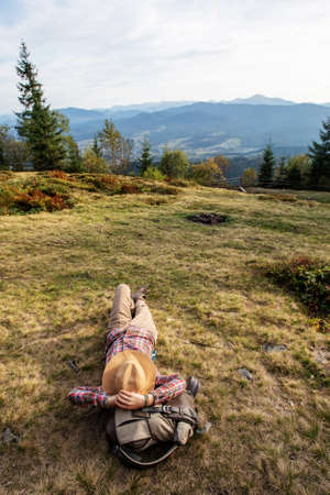 Woman hiker resting after climbing at sunsetの写真素材