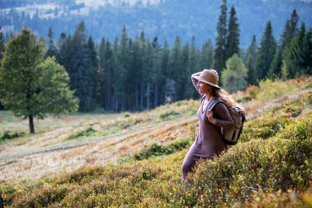Woman hiker resting after climbing at sunsetの写真素材