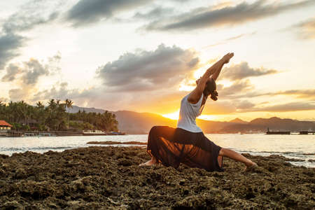 Woman doing yoga by the seaの写真素材