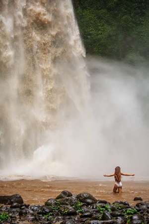 Beautiful woman near a waterfall in Baliの写真素材
