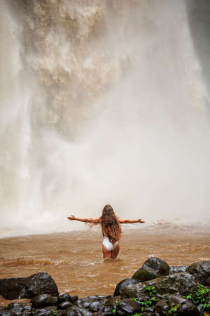Beautiful woman near a waterfall in Baliの写真素材