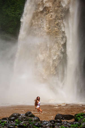 Beautiful woman near a waterfall in Baliの写真素材