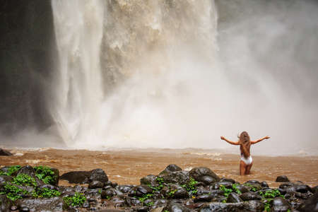 Beautiful woman near a waterfall in Baliの写真素材