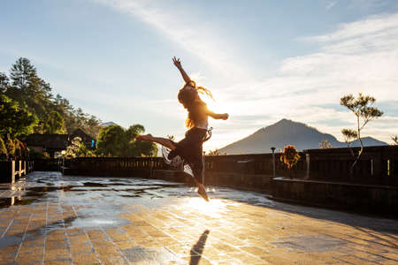 Woman doing yoga at dawn near a volcano on the island of Baliの写真素材