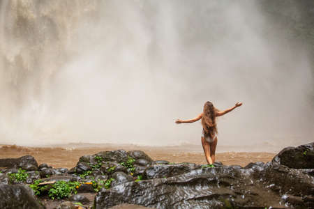 Beautiful woman near a waterfall in Baliの写真素材