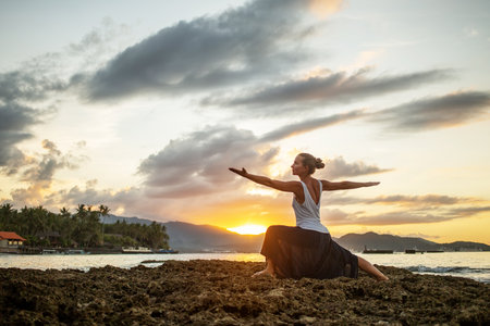 Woman doing yoga by the seaの写真素材