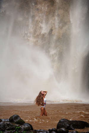 Beautiful woman near a waterfall in Baliの写真素材