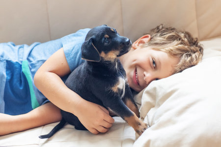 A boy with a little dog playing at homeの写真素材