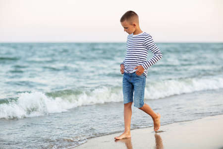 Portrait of a boy at sunset by the seaの写真素材
