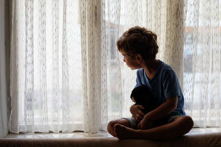 A boy with a little dog playing at homeの写真素材
