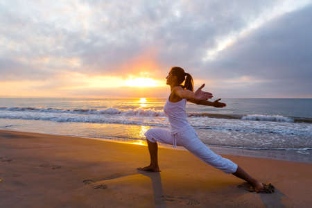 Beautiful woman doing yoga by the seaの写真素材