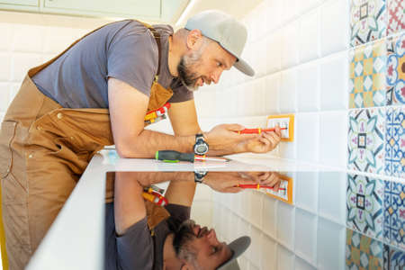 electrician repairs an outlet in the kitchenの写真素材