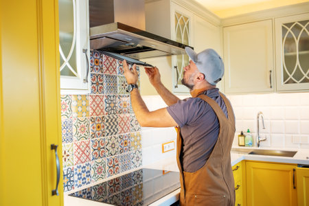 electrician repairs the hood in the kitchenの写真素材
