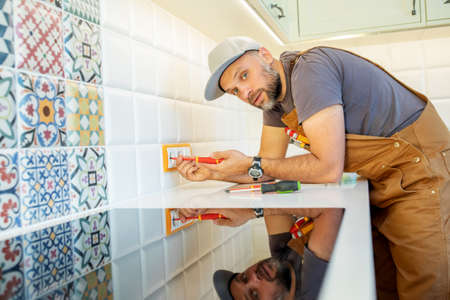 electrician repairs an outlet in the kitchen
