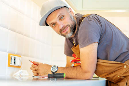 electrician repairs an outlet in the kitchenの写真素材
