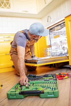 A man repairs a dishwasherの写真素材