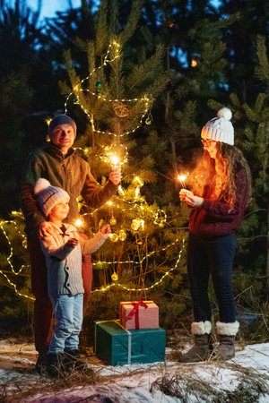 Happy family in the forest near the Christmas treeの写真素材