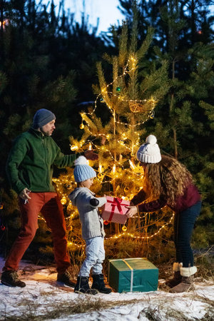 Happy family in the forest near the Christmas treeの写真素材