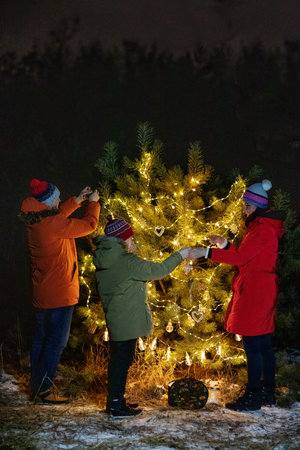 Happy family in the forest near the Christmas treeの写真素材
