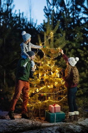 Happy family in the forest near the Christmas treeの写真素材