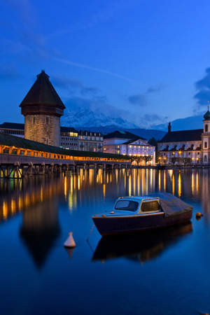 showing the famous Chapel Bridge reflected in the water at twilight, sundownの写真素材