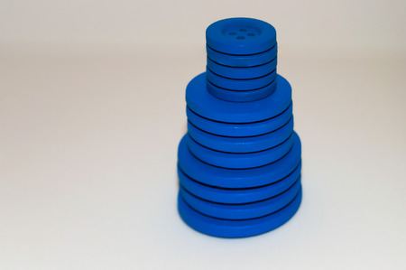 tower formed with blue buttons with white backgroundの写真素材