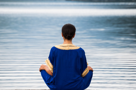 woman sitting on a pier at Lake Nelson in New Zealandの写真素材