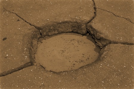 Asphalt sun. Pot in road with cracked like raysの写真素材
