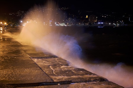 Water and light splash. Crashing waves on the promenade shoreの写真素材