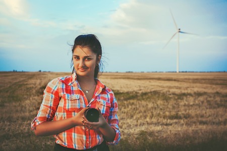 Brunette at sunset on the background of wind turbines.