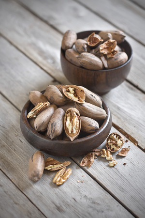 Raw pecans in wooden bowls. Selective focus.の写真素材