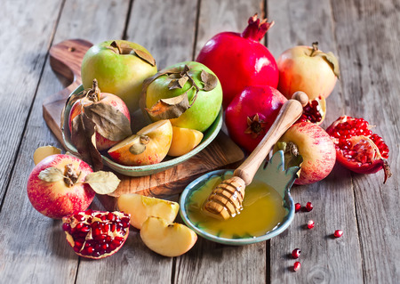 Pomegranate, apple and honey, traditional food of jewish New Year celebration, Rosh Hashana. Selective focus.の写真素材
