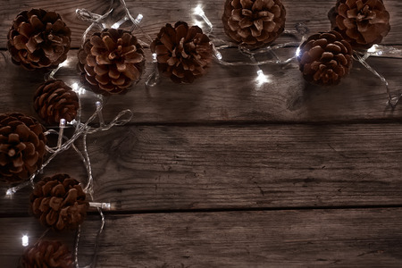 Vintage copy space background with pine cones and christmas garlandの写真素材