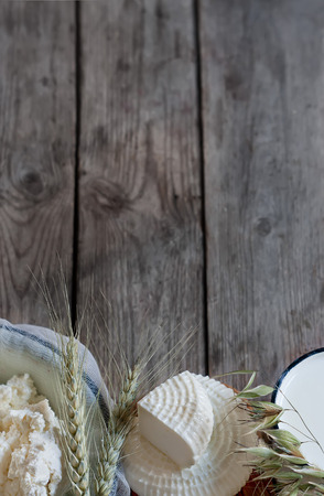 Tzfat cheese, milk, cottage cheese, wheat and oat grains on old wooden background. Concept of judaic holiday Shavuot.の写真素材