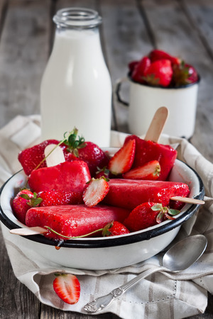 Strawberry homemade ice pops - with fresh ripe berries and bottle of milkの写真素材