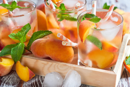 Homemade lemonade with ripe flat saturn-shaped peaches and fresh mintの写真素材