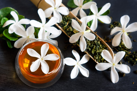 Cup of jasmine tea with bamboo scoop and blossomの写真素材