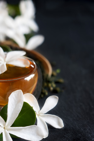 Cup of jasmine tea with bamboo scoop and blossom. Copy space background.の写真素材