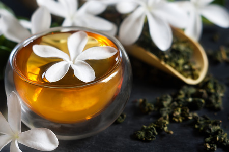 Cup of jasmine tea with bamboo scoop and blossomの写真素材