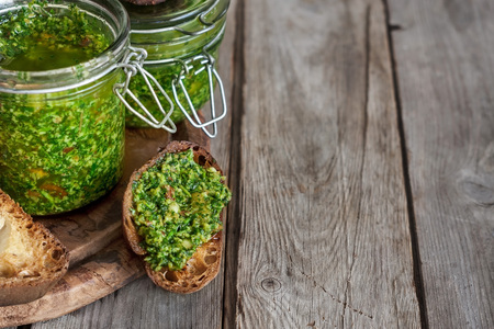 Homemade cilantro pesto in jars on wooden backgroundの写真素材